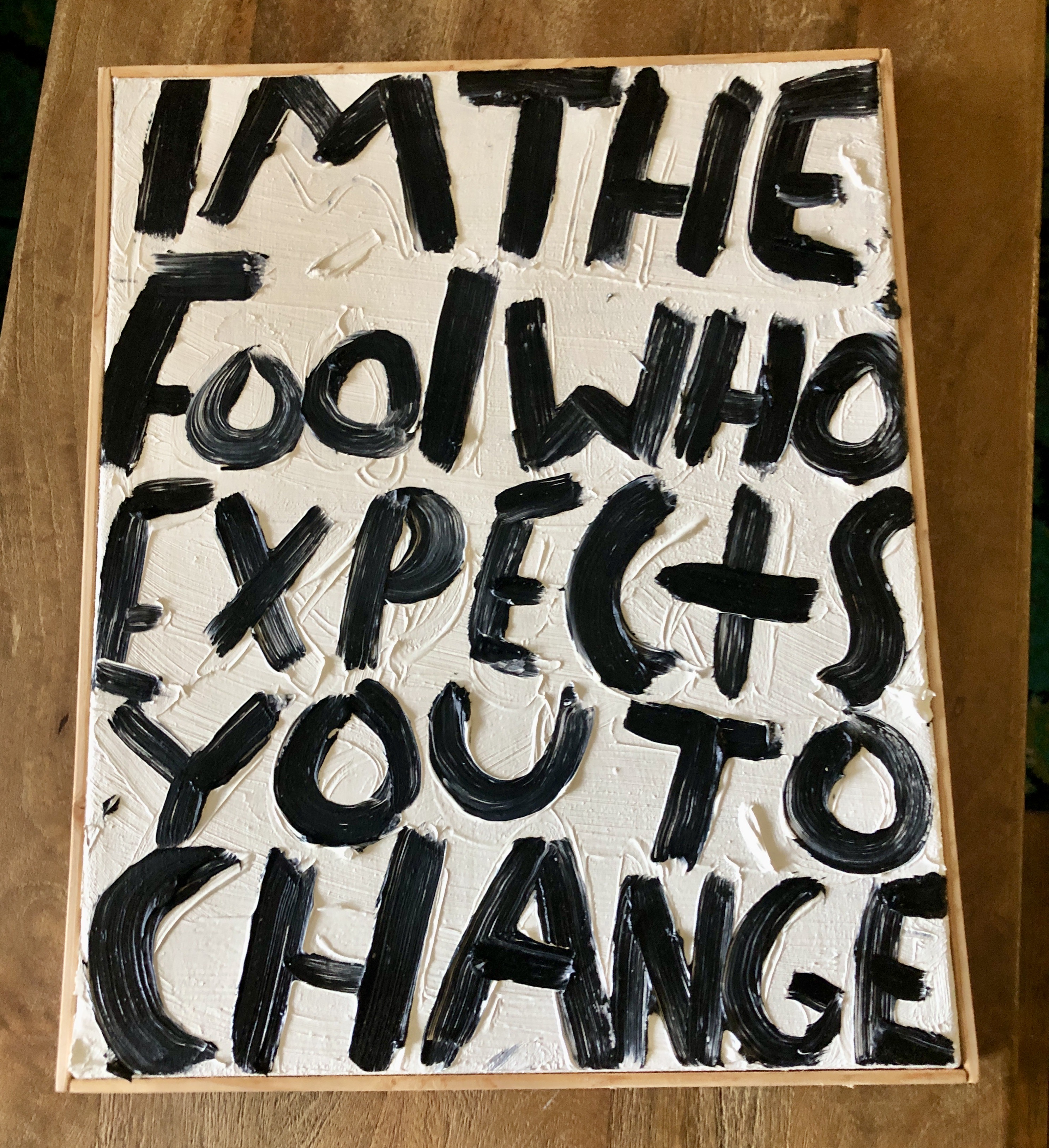 Eric Stefanski's I’m the Fool that Expects you to Change is an oil on canvas text art painting from 2023. It depicts the title in black letters on a white background.